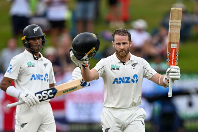 Kane Williamson takes off his helmet and raises his bat