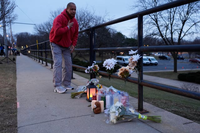 A person who did not wish to give his name places flowers outside the Abundant Life Christian School