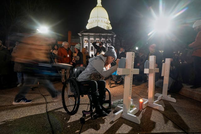 A supporter signs a cross during a candlelight vigil outside the Wisconsin Capitol in Madison 