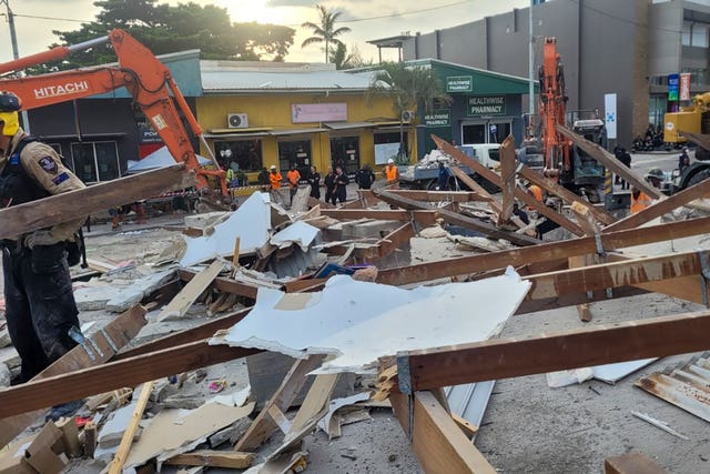 Australian rescue workers inspect a damaged building in Vanuatu