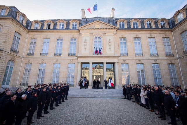 People stand in silent tribute at the Elysee Palace