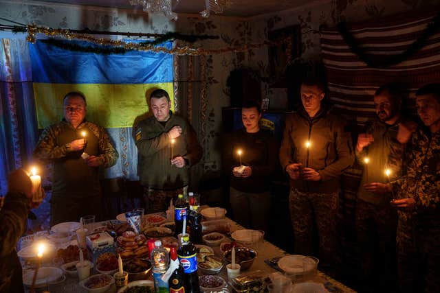 Ukrainian servicemen praying before a Christmas dinner in Donetsk