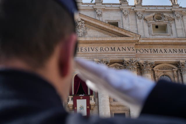 A Vatican gendarmerie officer salutes as Pope Francis prepares to deliver the Urbi et Orbi (Latin for ‘to the city and to the world’ ) Christmas Day blessing from the main balcony of St Peter’s Basilica at the Vatican