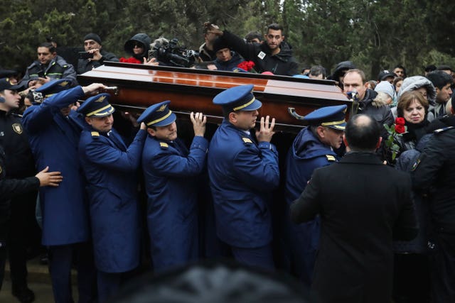 Pilots carry a coffin during a funeral of the crew members of the Azerbaijan Airlines plane