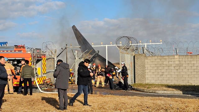 Firefighters and rescue team members work at the Muan International Airport