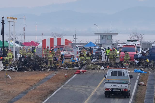 Rescue team members work at the site of the plane crash in South Korea