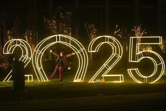 An Egyptian poses in front of new year decorations in Cairo, Egypt