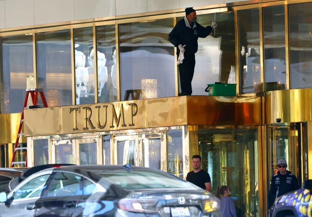 A worker cleans glass windows at Trump International Hotel