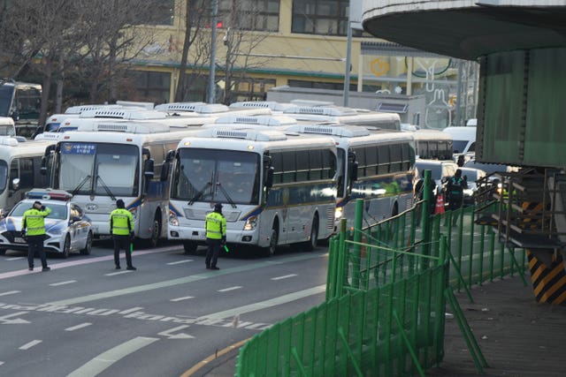 Vehicles, right, carrying investigators from the Corruption Investigation Office for High-ranking Officials arrive at the gate of the presidential residence 