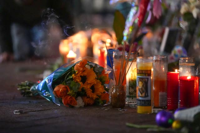 Flowers lie next to candles at a memorial for the victims of the attack