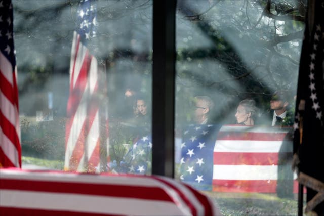 Family members are reflected as they listen during a service at the flag-draped coffin of former US president Jimmy Carter at the Jimmy Carter Presidential Library and Museum in Atlanta 