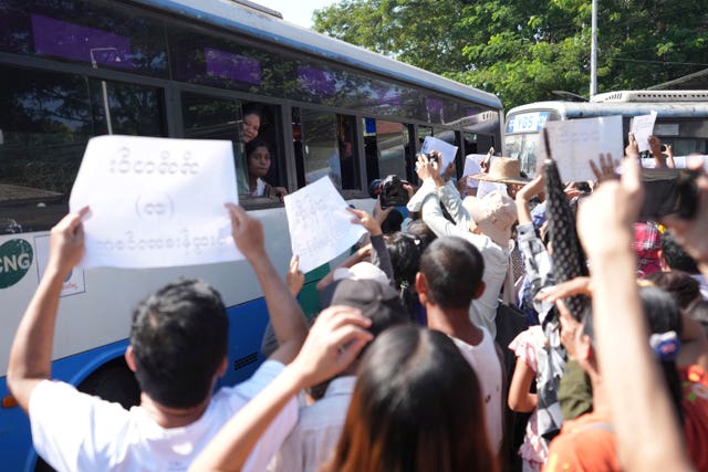 A bus carrying released prisoners is welcomed by family members