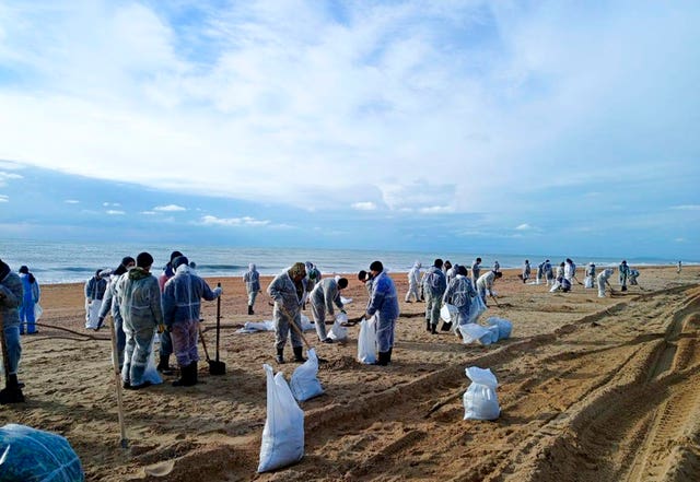 Work to treat and contain an oil spill on a beach