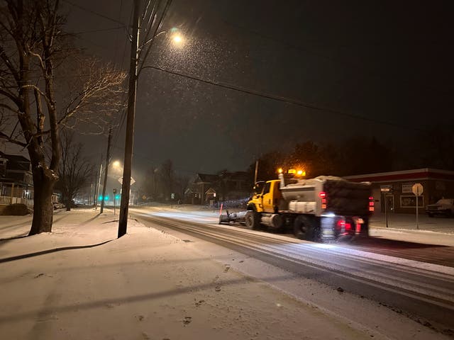 A snowplough travels along a snowy road