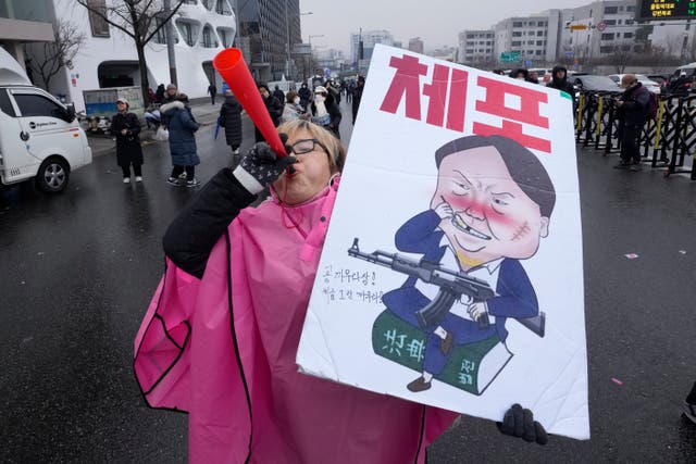 A protester blows a vuvuzela during a rally 