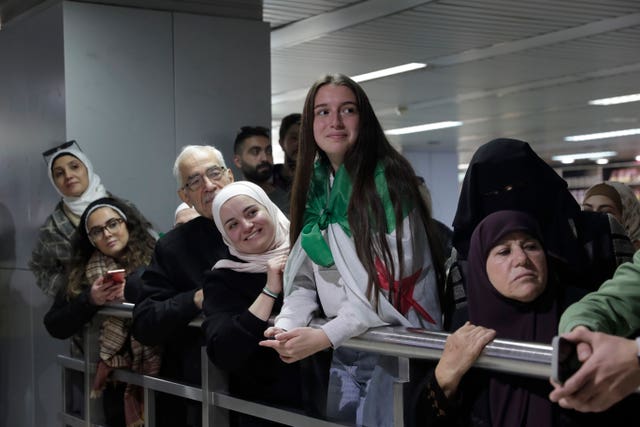 People wait to receive their relatives at the arrival terminal at Damascus airport