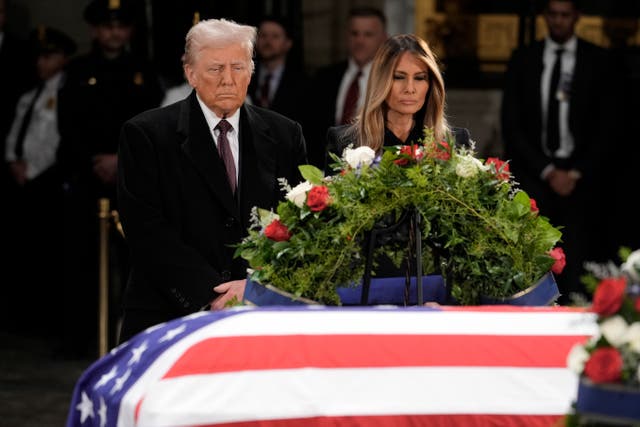 President-elect Donald Trump and his wife Melania Trump pause at the flag-draped casket of former president Jimmy Carter as he lies in state in the rotunda of the US Capitol in Washington 