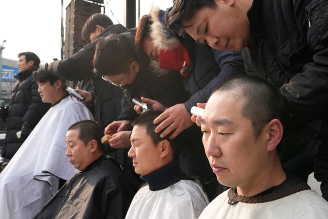 Supporters of impeached South Korean President Yoon Suk Yeol have their heads shaved as they attend a rally to oppose his impeachment near the presidential residence in Seoul