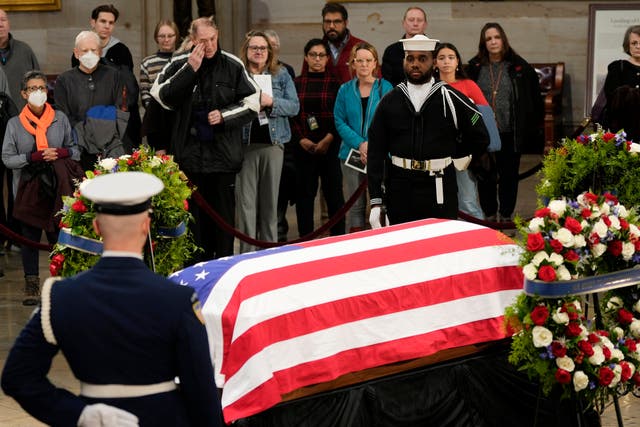 Guests pay their respects as the flag-draped casket of former President Jimmy Carter