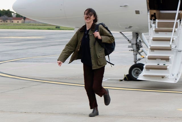 Ms Scala walks across the tarmac after getting off a plane