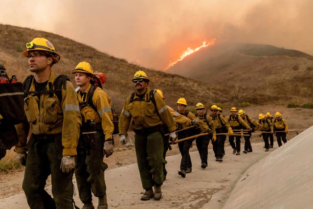 Fire crews walk as they battle the Kenneth Fire in the West Hills section of Los Angeles 