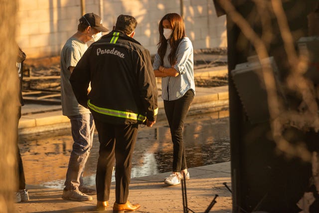 Meghan speaks to Pasadena mayor Victor Gordo, centre, and Doug Goodwin, whose home was destroyed by fire