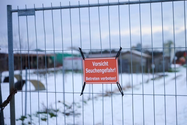 A sign that reads Caution risk of epidemic, on a fence