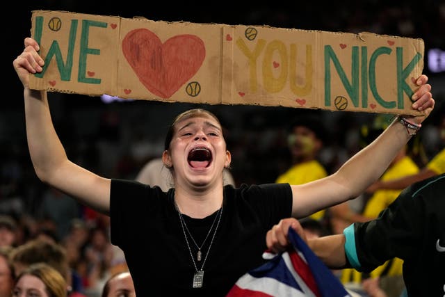 A fans holds up a 'We love you Nick' banner in the crowd