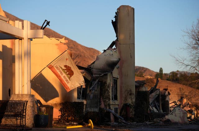 A California state flag hangs outside the charred remains of the Terraces at Park Marino assisted living facility in Pasadena, California