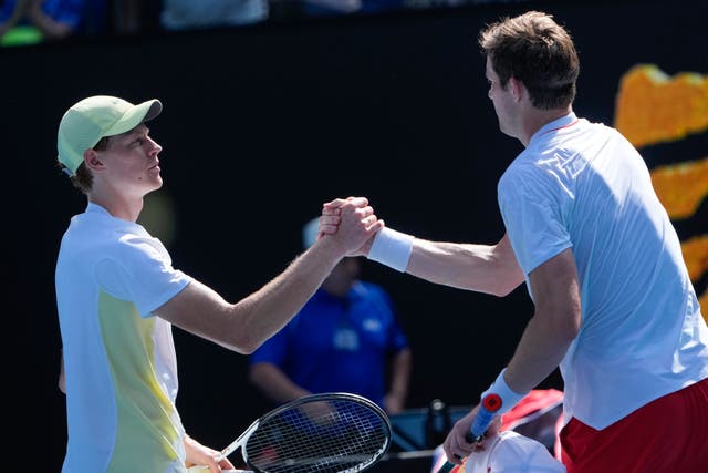 Jannik Sinner, left, shakes hands with Nicolas Jarry