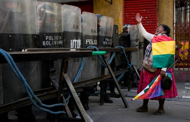 Police block a road to the presidential palace as a supporter of former president Evo Morales shouts during an anti-government protest in La Paz