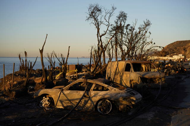 Charred vehicles sit along the Pacific Coast Highway in Malibu, California