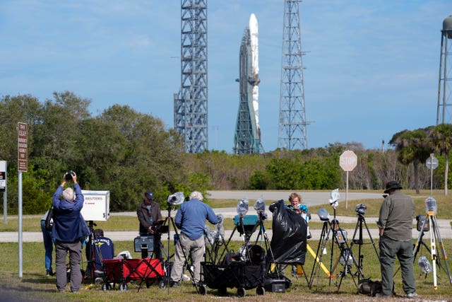 Photographers at the Cape Canaveral Space Force Station with the New Glenn rocket in the background