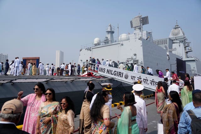 Indian naval officers walk with their family members after the commissioning 