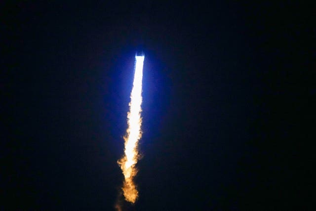 The New Glenn rocket heading into space in dark night sky