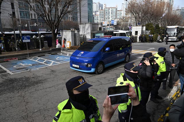 A blue van carrying impeached South Korean President Yoon Suk Yeol arrives at Seoul Western District Court