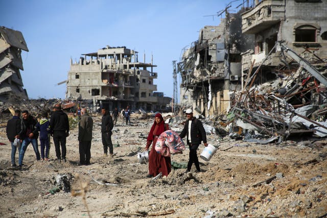 Palestinians inspect the destruction caused by the Israeli air and ground offensive in Rafah, as a ceasefire deal between Israel and Hamas went into effect