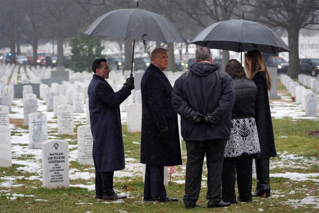 President-elect Donald Trump and Melania Trump talk with family members of Army Staff Sgt. Ryan Christian Knauss, in Section 60 at Arlington National Cemetery