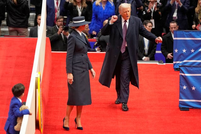 President Donald Trump and first lady Melania Trump arrive at an indoor presidential inauguration parade event in Washington