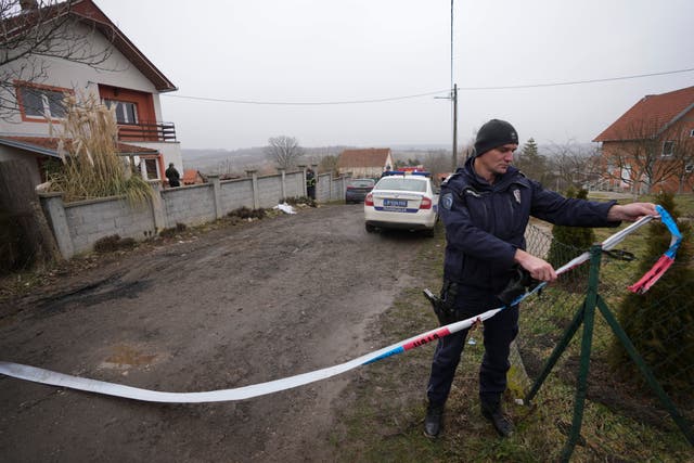 A police officer puts up tape at the scene