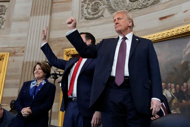 President Donald Trump gestures as he is joined on stage by vice president JD Vance after being sworn in as the 47th president of the United States during the 60th Presidential Inauguration in the Rotunda of the US Capitol in Washington 