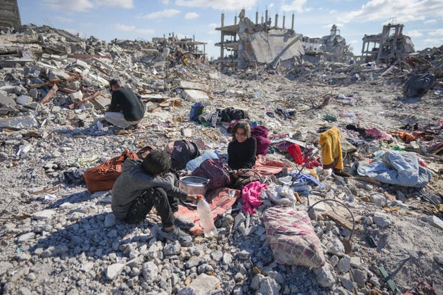 Nour and her brother Mohamed Ballas try to salvage what they can of their belongings from the rubble of their home in Rafah