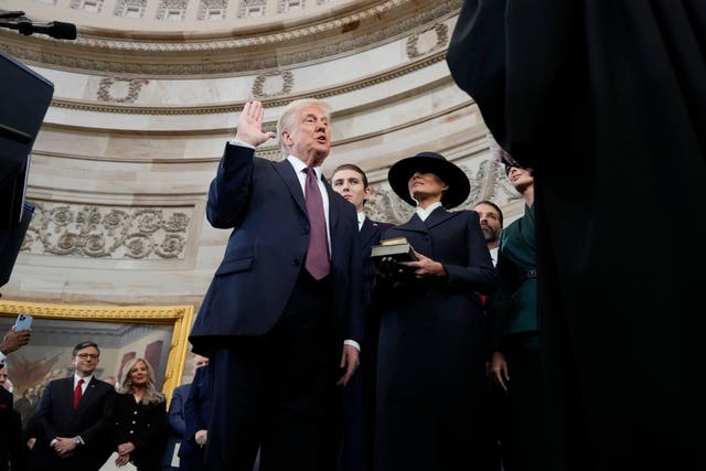 Donald Trump is sworn in as the 47th president of the United States by Chief Justice John Roberts as Melania Trump holds the Bible during the 60th Presidential Inauguration in the Rotunda of the US Capitol in Washington