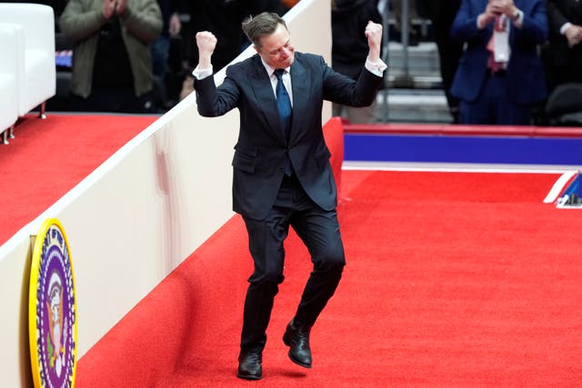 Elon Musk arrives on stage to speak at an indoor presidential inauguration parade event in Washington