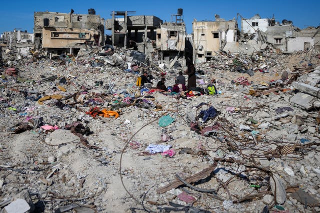 Palestinians search for their belongings under the rubble of destroyed homes in Rafah