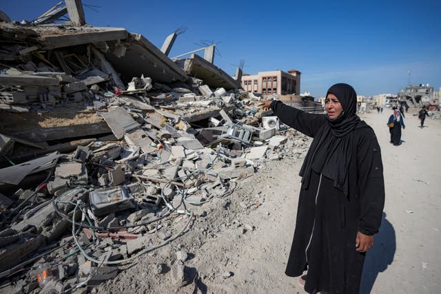 Manual Aslim reacts next to the ruins of her destroyed home