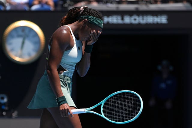 Coco Gauff covers her face with her hand