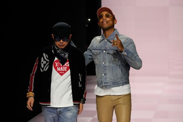 Pharrell Williams, right, walks with with Nigo, artistic designer for Kenzo, with who co-creates a collection, after the men's Louis Vuitton Fall-Winter 2025-2026 collection, that was presented in Paris