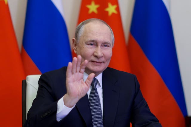 Russian President Vladimir Putin, gestures as he speaks with Chinese President Xi Jinping via videoconference