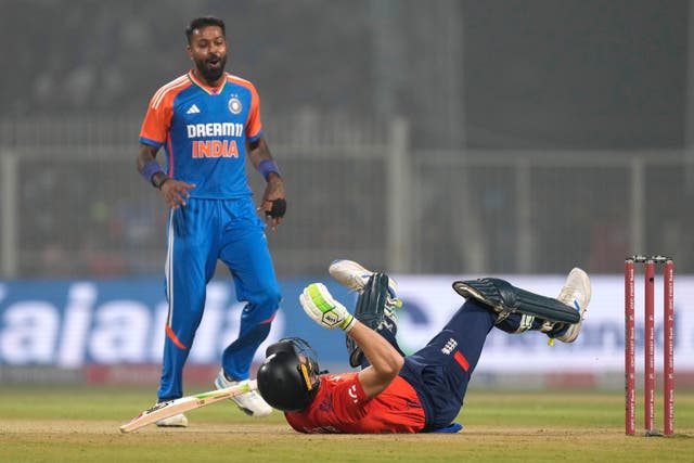 Jos Buttler falls on the ground in an attempt to play a shot against Hardik Pandya